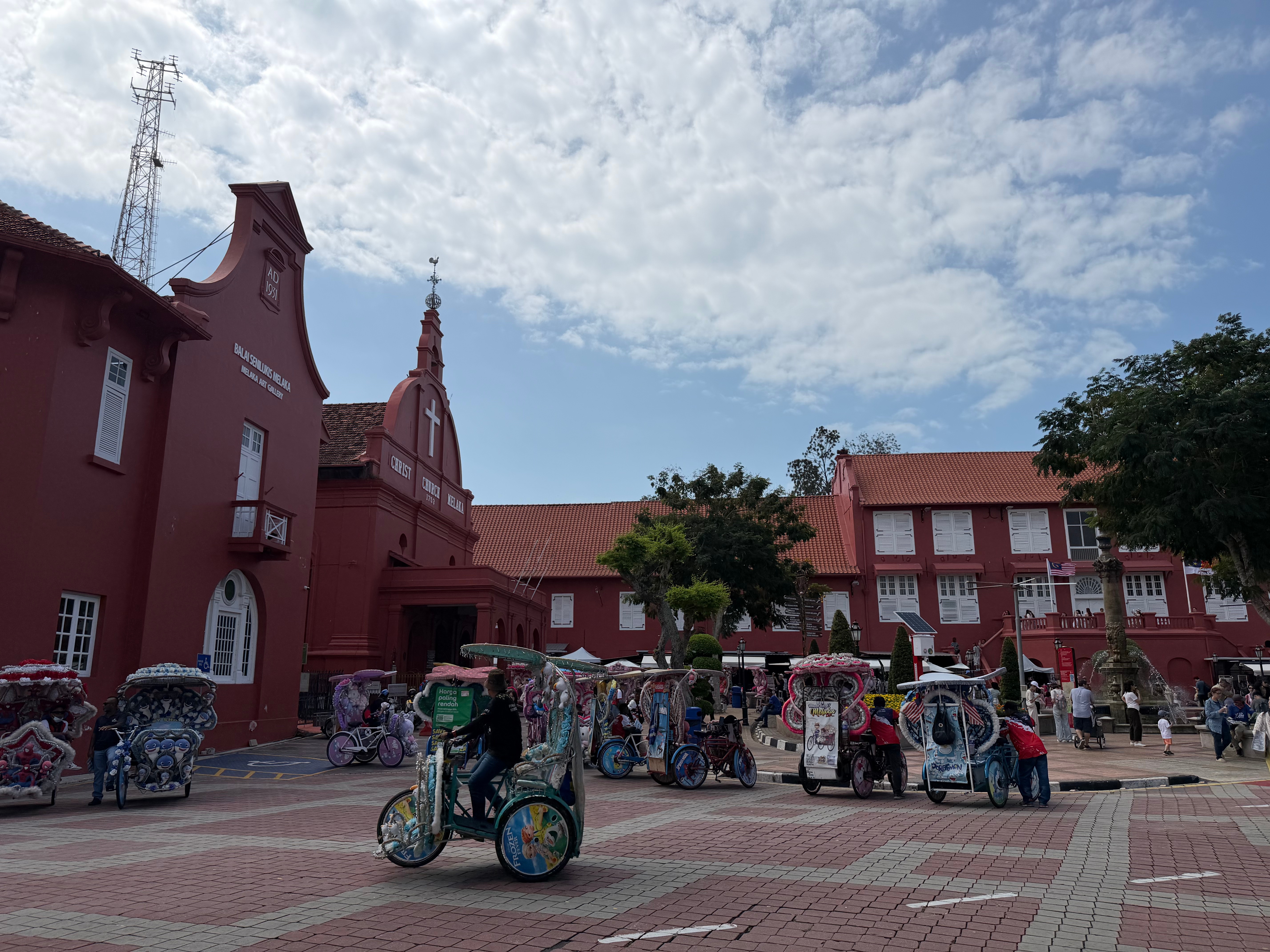 Melaka Dutch Square and Melaka Town Hall with red buildings, Victoria fountain and local rickshaws